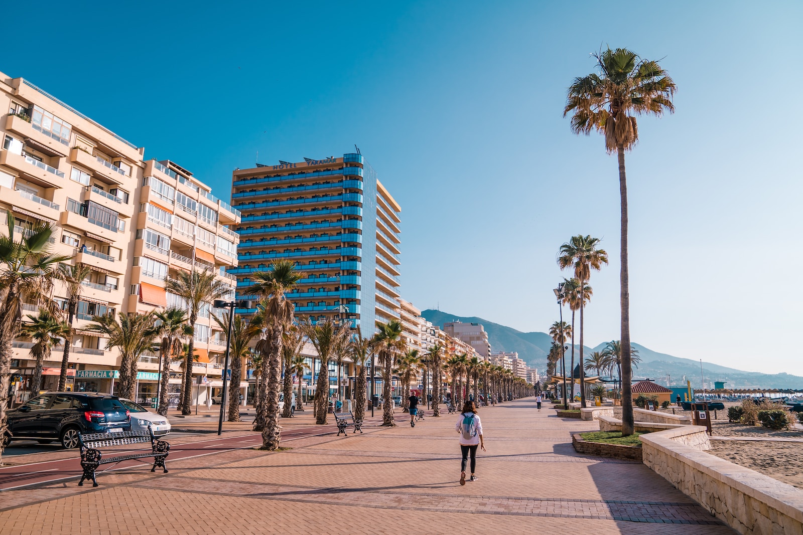 a man walking down a street next to tall buildings